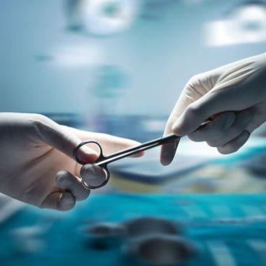 43694797 - healthcare and medical concept , close-up of surgeons hands holding surgical scissors and passing surgical equipment , motion blur background.
